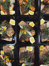 Assorted nutrient-dense meal prep dishes featuring wild-caught seafood and grass-fed protein